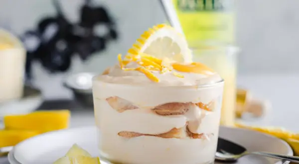Un délicieux tiramisu limoncello, superposé de biscuits et de crème, garni d'une tranche de citron et de zestes.