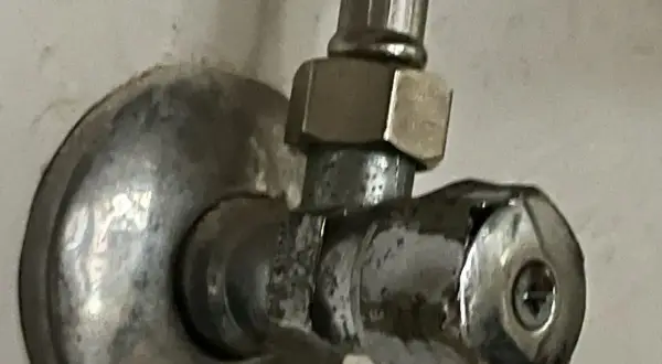Metalowy zawór z widocznym uszkodzeniem. Może to być pomocne przy próbie jak wykręcić urwany zawór.