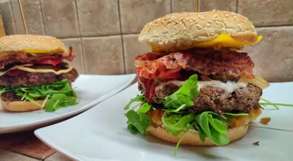 Dwa soczyste burgery wołowe z bekonem, serem i rukolą. Idealne, gdy zastanawiasz się, jak smażyć wołowinę na burgery.