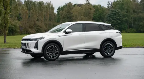 Biały SUV Omoda 9 na mokrej nawierzchni. Sprawdź, jaka jest omoda 9 cena i czy warto zainwestować w ten model.