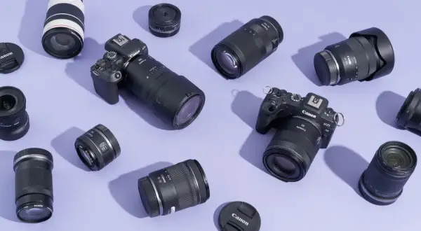 A collection of Canon EOS R cameras and various best L series lenses, including zooms and primes, are artfully arranged on a lavender background.