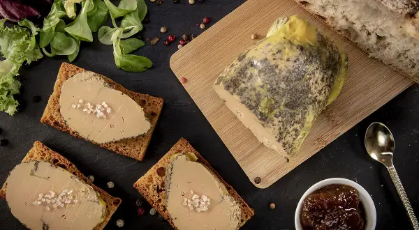 Tranches de foie gras sur toasts, accompagnées de pain frais, d'une compotée de fruits et d'une touche de cognac ou d'armagnac.