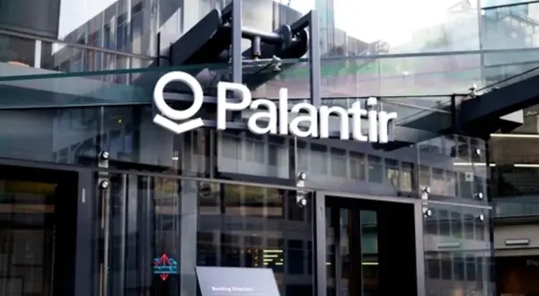 Logo Palantir na nowoczesnym budynku z przeszkloną fasadą.