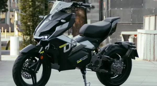 Moderna repro moto 125 eléctrica, negra y futurista, aparcada en la calle.