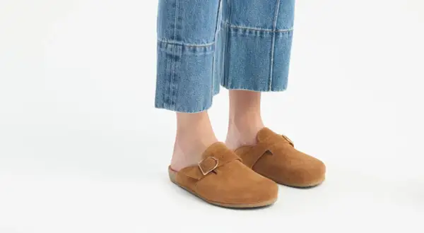 Brązowe zamszowe klapki z klamrą idealnie pasują do jeansów mom. Stylowe i wygodne buty na co dzień.