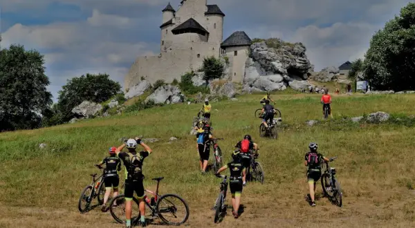 Grupa rowerzystów zdobywa zamek na Jurze Krakowsko-Częstochowskiej.