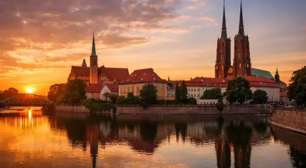Zachód słońca nad Odrą we Wrocławiu, województwo. Katedra i zabytkowe budynki odbijają się w wodzie.