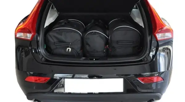 Tre svarta resväskor fyllda i volvo v40 bagageutrymme. Perfekt för en weekendresa!