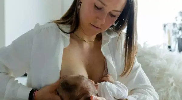 Eine Mutter stillt ihr Baby. Bei Fragen zu milchstau was tun, ist diese intime Szene ein wichtiger Hinweis auf die natürliche Nahrungsaufnahme.