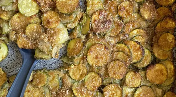 Fette di zucchine al forno, dorate e croccanti, con pangrattato e parmigiano. Un contorno saporito e facile da preparare.