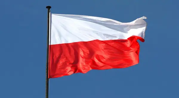 Biało-czerwona flaga Polski powiewa na wietrze. To symbol wolności, jak w piosence "Co to jest niepodległość tekst".