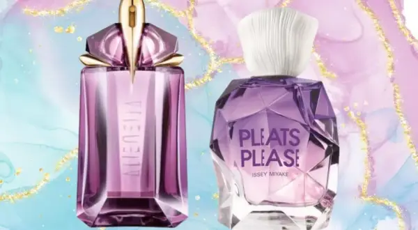 Dwie fioletowe butelki perfum na pastelowym tle z brokatem.