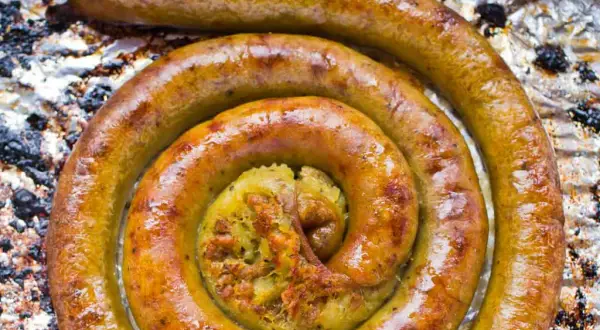 Złocista kiszka ziemniaczana zwinięta w spiralę na folii aluminiowej.