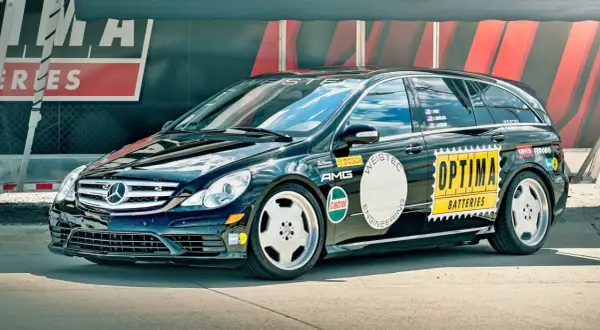 Czarny Mercedes R-klasy z naklejkami "OPTIMA BATTERIES", "AMG", "WEISTEC". To auto z serii r63.
