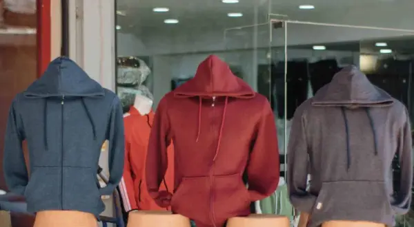 Drei Hoodies in Blau, Rot und Grau. Ein Sweatshirt ist ein bequemes Kleidungsstück mit Kapuze.