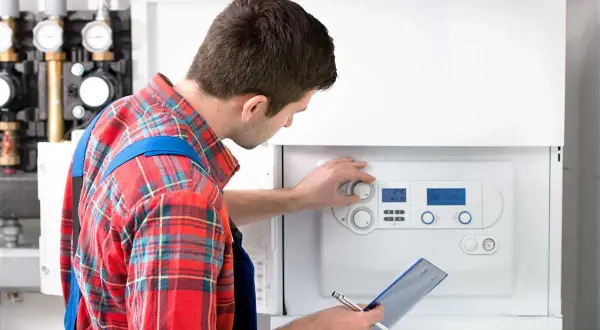 Tecnico controlla la caldaia, un promemoria per la manutenzione caldaia ogni quanto.