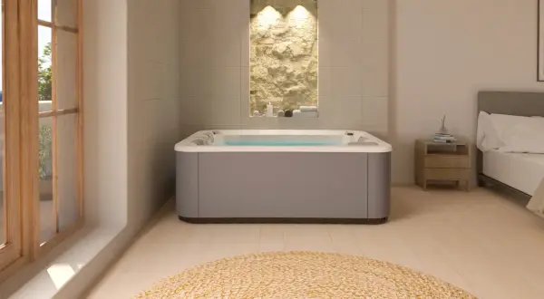 Nowoczesne jacuzzi w łazience z kamienną ścianą i widokiem na balkon.