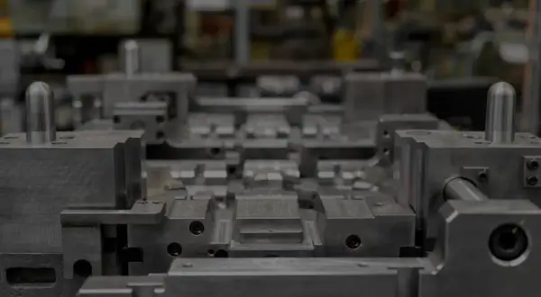Precyzyjna budowa form wtryskowych w zakładzie produkcyjnym. Metalowe elementy tworzą skomplikowaną strukturę gotową do pracy.
