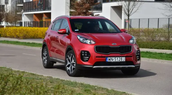 Czerwony Kia Sportage 4 na drodze, gotowy do wymiany żarówki.