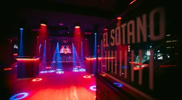 El Sótano, un club techno con luces rojas y azules, pista de baile vacía y DJ listo para la acción.