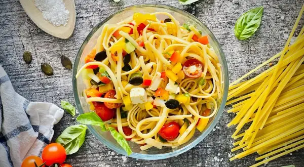 Bunter Spaghetti-Salat zum Grillen mit Tomaten, Paprika, Oliven und Feta. Perfekt als Beilage!