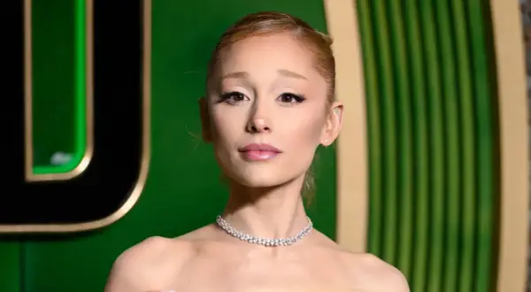 Ariana Grande w błyszczącym naszyjniku, wygląda na zmęczoną, jakby zmagała się z chorobą.