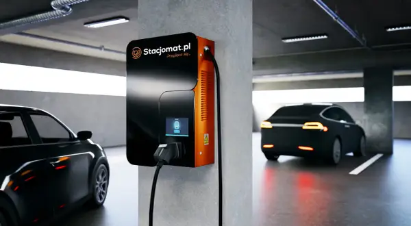 Nowoczesna ładowarka Stacjomat.pl w garażu podziemnym. Samochód elektryczny czeka na podłączenie, zgodnie z przepisami.