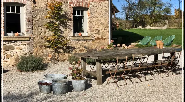 Rusty metal chairs await guests at a rustic table outside a stone building. Ideal agroturystyka Dolny Śląsk.