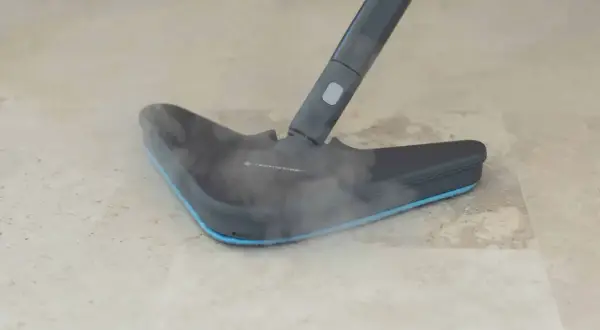 Dampfreiniger mit Dampf auf hellem Laminatboden.