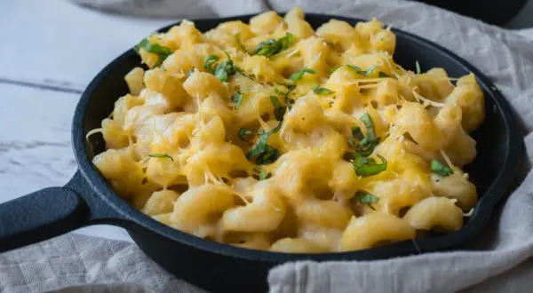 Krämig vegansk mac and cheese i gjutjärnspanna, toppad med färska örter. Enkel och god comfort food.