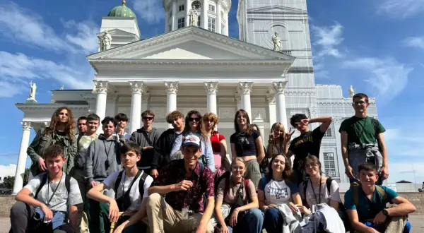 Grupa młodych ludzi pozuje przed Katedrą w Helsinkach, stolicy Finlandii.