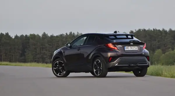 Ciemnobrązowa Toyota C-HR z czarnymi felgami na tle lasu. Czy to auto ma jakieś usterki?