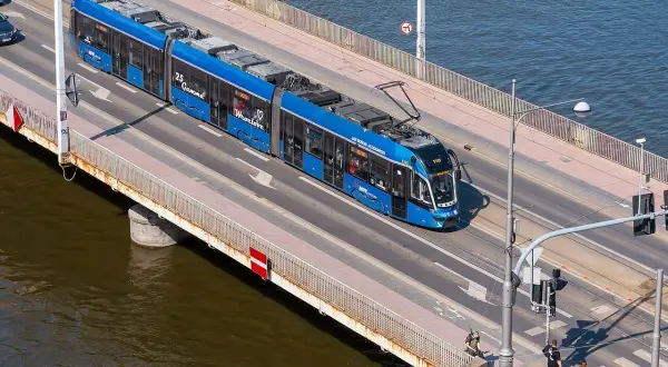 Blauer Straßenbahnzug fährt über eine Brücke, auf dem Weg von Görlitz nach Breslau.