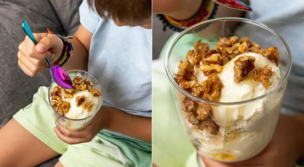 Ein Kind genießt ein Glas cremiges griechischer joghurt eis ohne eismaschine, garniert mit Honig und Nüssen.