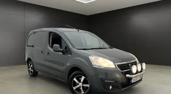 Grå Peugeot Partner skåpbil med extraljus. Tänk på peugeot kamremsbyte intervall för att hålla den i toppskick.