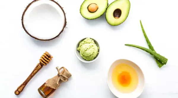 Ingredientes para una mascarilla casera para el pelo: coco, aguacate, aloe vera, miel y huevo.