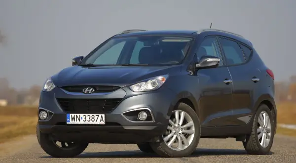 Szary Hyundai ix35 na drodze. Wymiana żarówki mijania w tym modelu jest prosta.