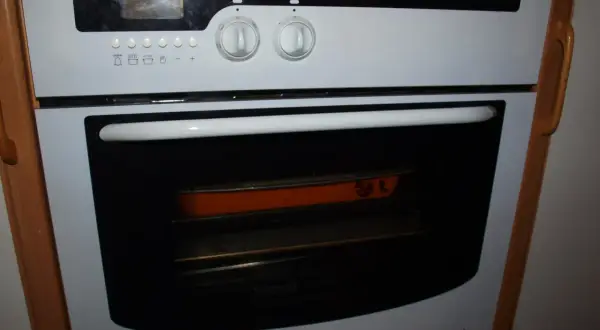 Piekarnik Mastercook z pomarańczową brytfanną w środku. Dowiedz się, jak zresetować piekarnik Mastercook, gdy coś pójdzie nie tak.