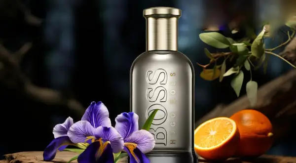 Elegancki flakon Hugo Boss Bottled 100ml otoczony fioletowymi irysami i soczystymi pomarańczami, sugeruje świeżość i wyrafinowanie.