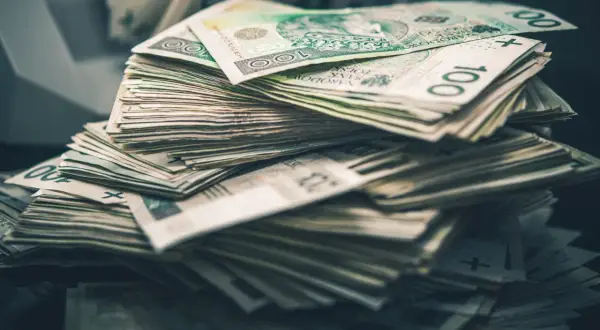 Góra stosu polskich banknotów 100 zł. Taka ilość pieniędzy to dla wielu osób symbol zadośćuczynienia i spełnienia marzeń.