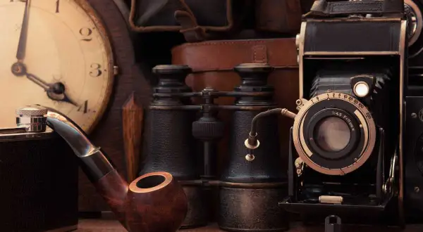 Una pipa, binocolo, macchina fotografica antica e orologio da tasca: oggetti antichi più ricercati, che evocano storie del passato.