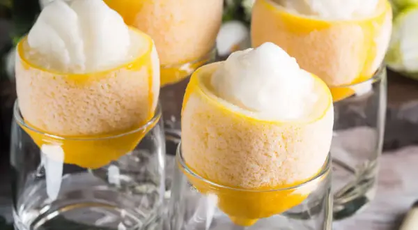 Erfrischendes Sorbetto al limone, serviert in ausgehöhlten Zitronen, die in Gläsern stehen.