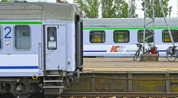 Nowe wagony PKP Intercity z zielonym pasem czekają na pasażerów. Na peronie stoją rowery.
