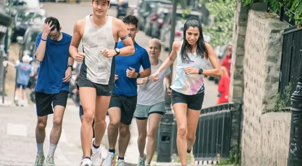 Un groupe de coureurs s'entraîne dans les rues pavées, une course qui rappelle une **corrida auch** par son énergie.