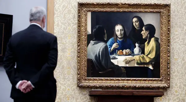 Mężczyzna w garniturze podziwia "Chrystusa w domu Marii i Marty", jeden z wielu wspaniałych **Vermeer obrazy**.