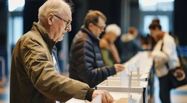 Starszy pan głosuje. Dowiedz się, jak zgłosić się do komisji wyborczej, aby pomóc w procesie.