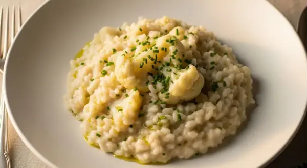 Cremoso risotto de coliflor, coronado con floretes tiernos y cebollino fresco. Un plato reconfortante y lleno de sabor.