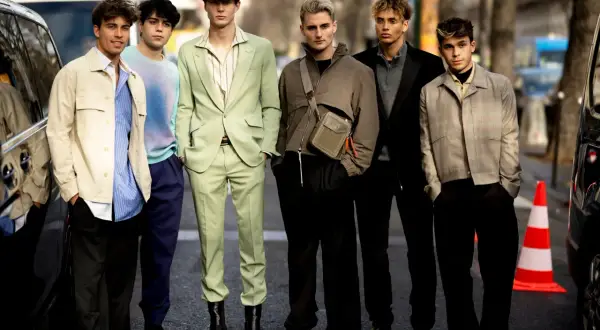 Sechs junge Männer präsentieren modische Outfits. Einer trägt einen schwarzen Blazer, der elegant zu kombinieren ist.