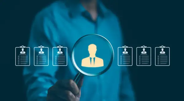 Szukamy idealnego kandydata. Lupa powiększa sylwetkę pracownika, pokazując, jak działa agencja pracy, dopasowując talenty do firm.