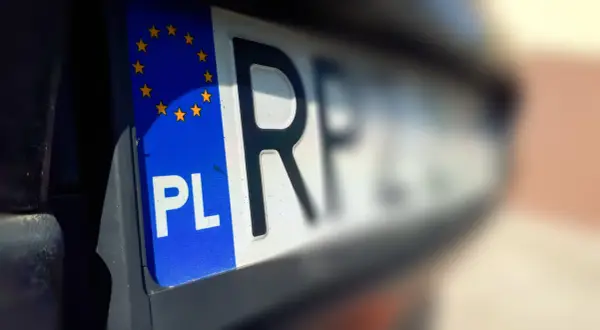 Zbliżenie na polską tablicę rejestracyjną z symbolem UE. Szybkie wyrejestrowanie auta online jest teraz możliwe.
